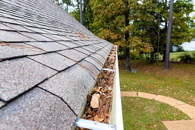 removing dirt and grime from rain gutter with high-tech equipment